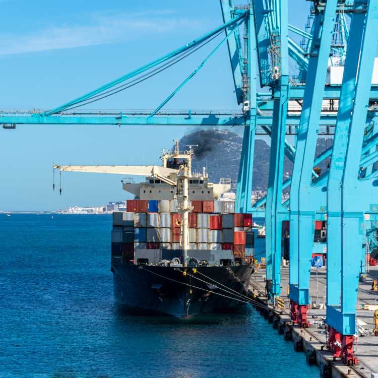 Container ship aerial view moving through open water.